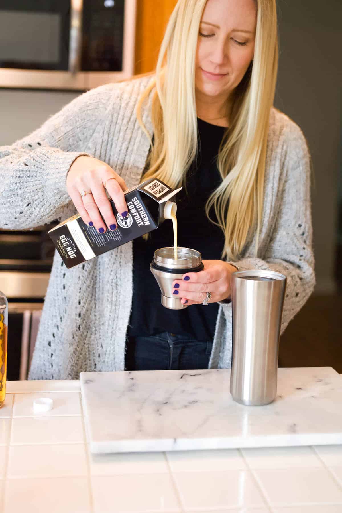 Woman measuring eggnog for a cocktail.
