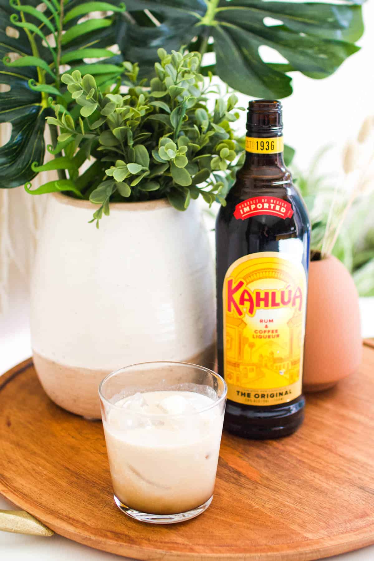 A classic White Russian cocktail on a tray with Kahlua.