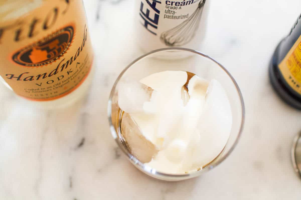 Overhead shot of a cocktail glass with heavy cream over ice and Kahlua.