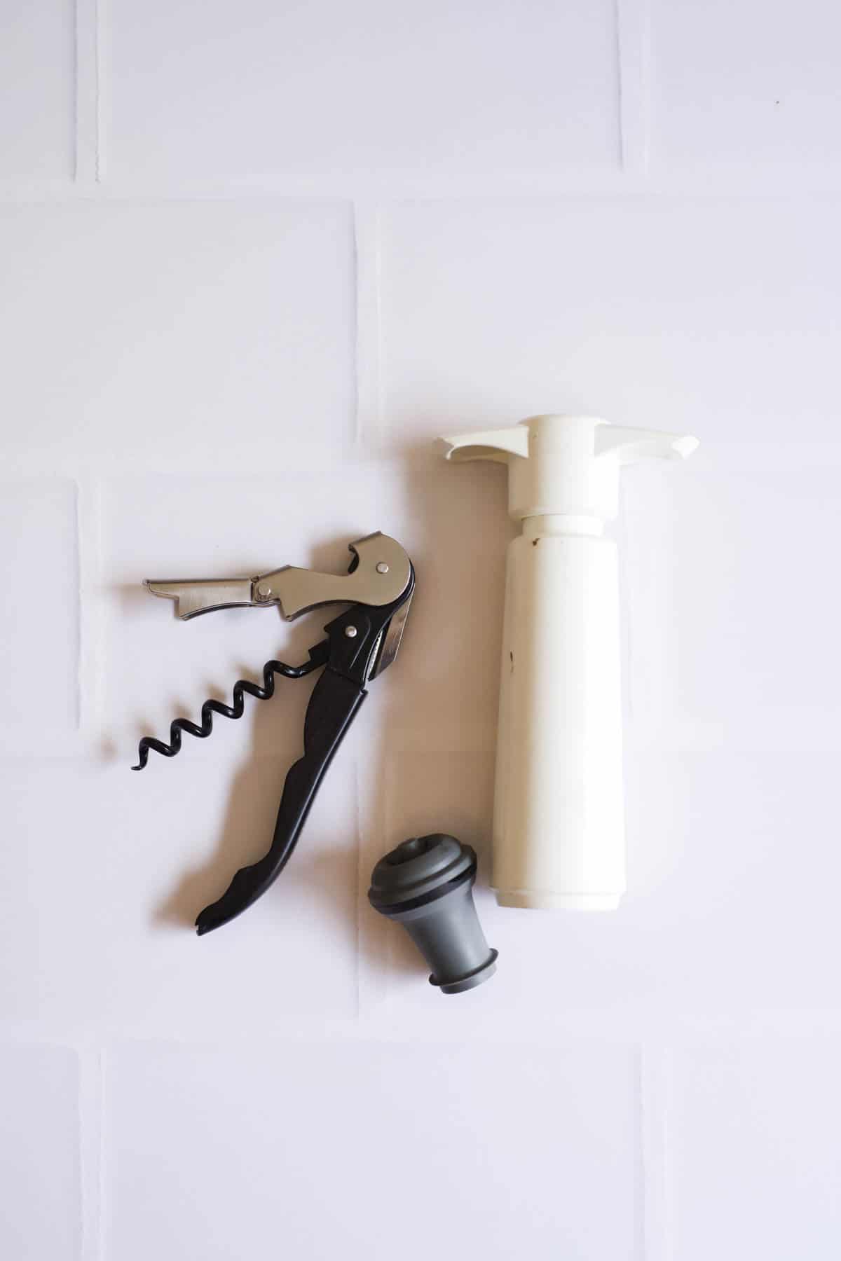 A wine key and vacuum wine sealer system on a table.