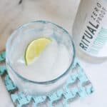 Overhead of a non alcoholic gin and tonic on a table with a wedge of lime.