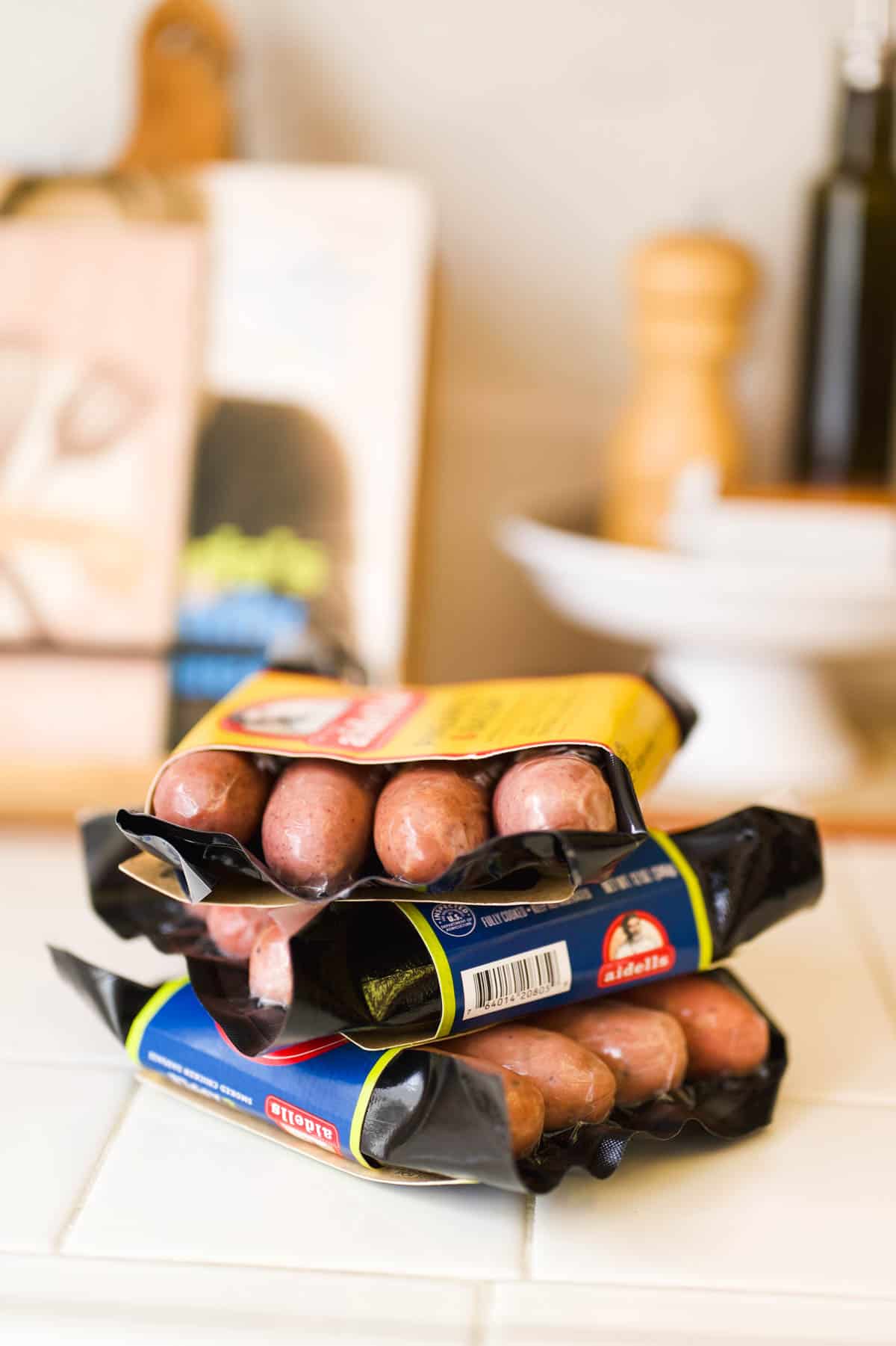 Packages of apple sausage stacked on the counter.