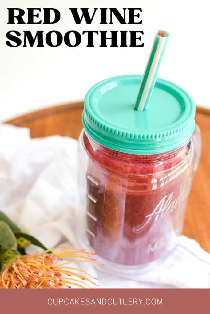 Red wine smoothie in a mason jar glass with a blue lid and straw.