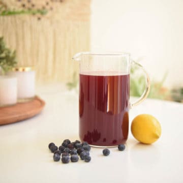 Close up of a pitcher with a lemonade flavored with blueberry.