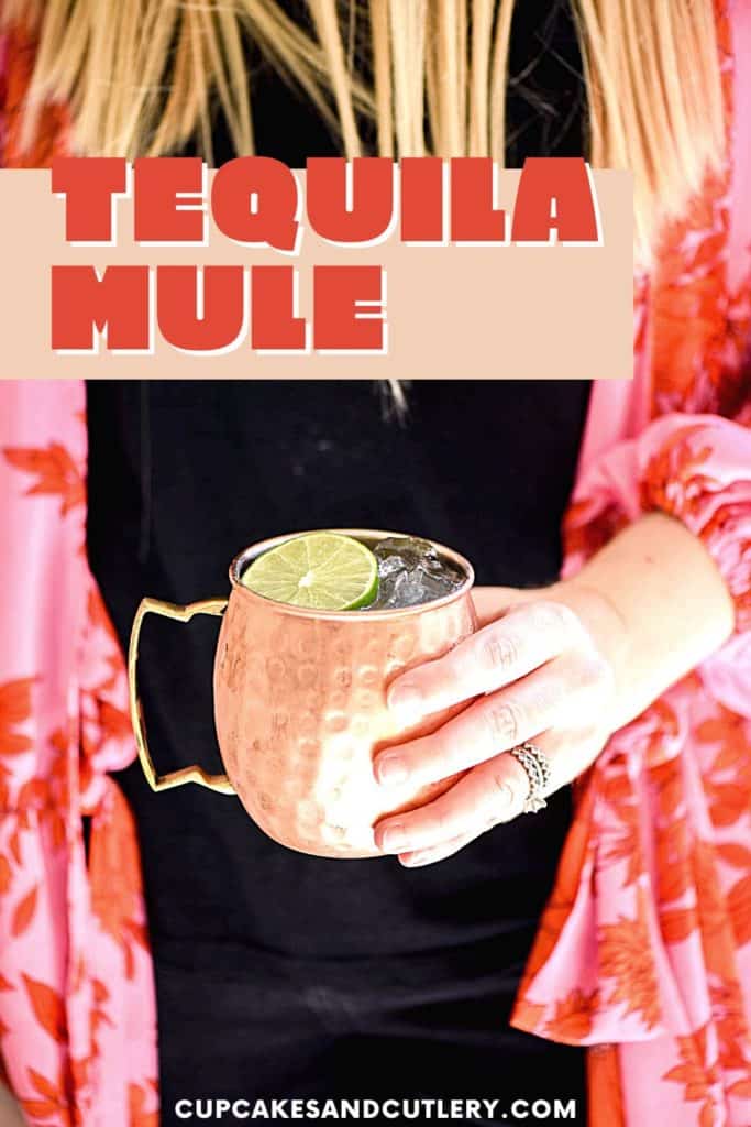 Woman holding a copper mug filled with a tequila mule.