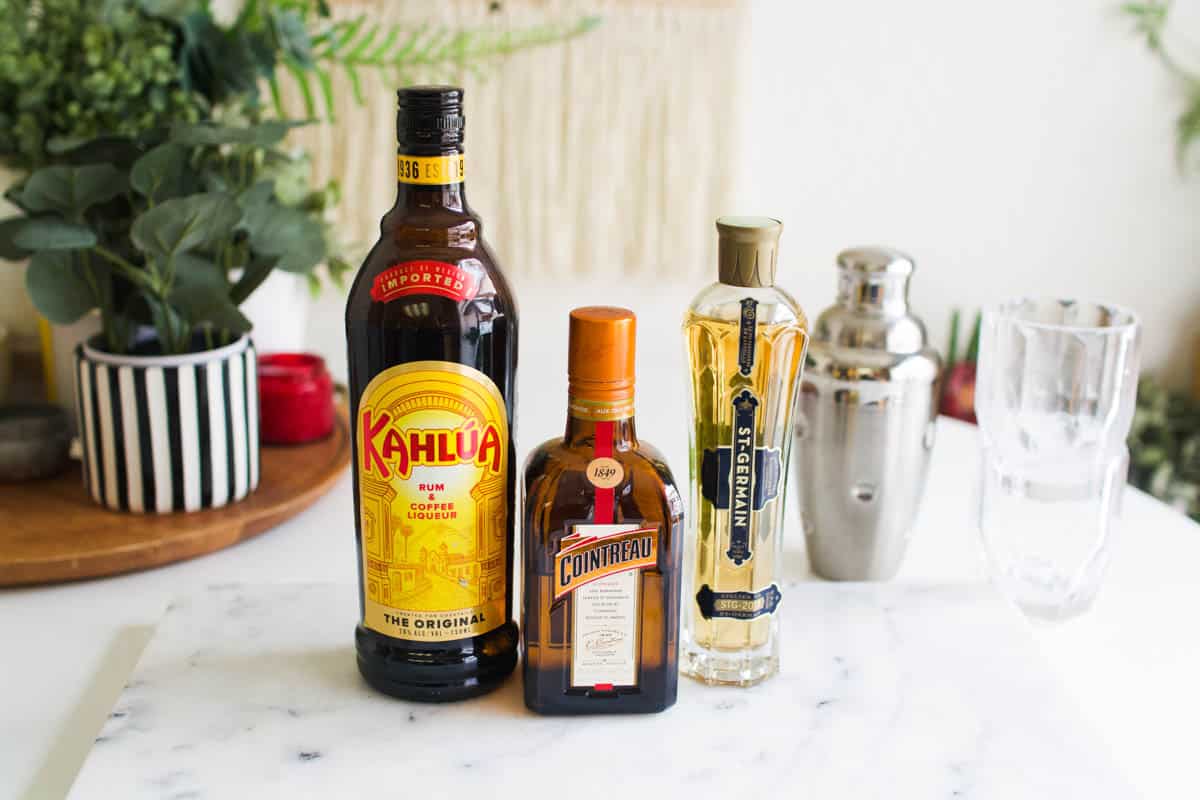 Bottles of Kahlua, Cointreau and Ste. Germain on a table.