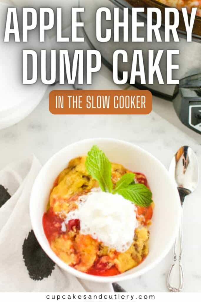 Text: Apple Cherry Dump Cake in the slow cooker with a white dessert bowl holding some dessert topped with whipped cream next to a slow cooker.