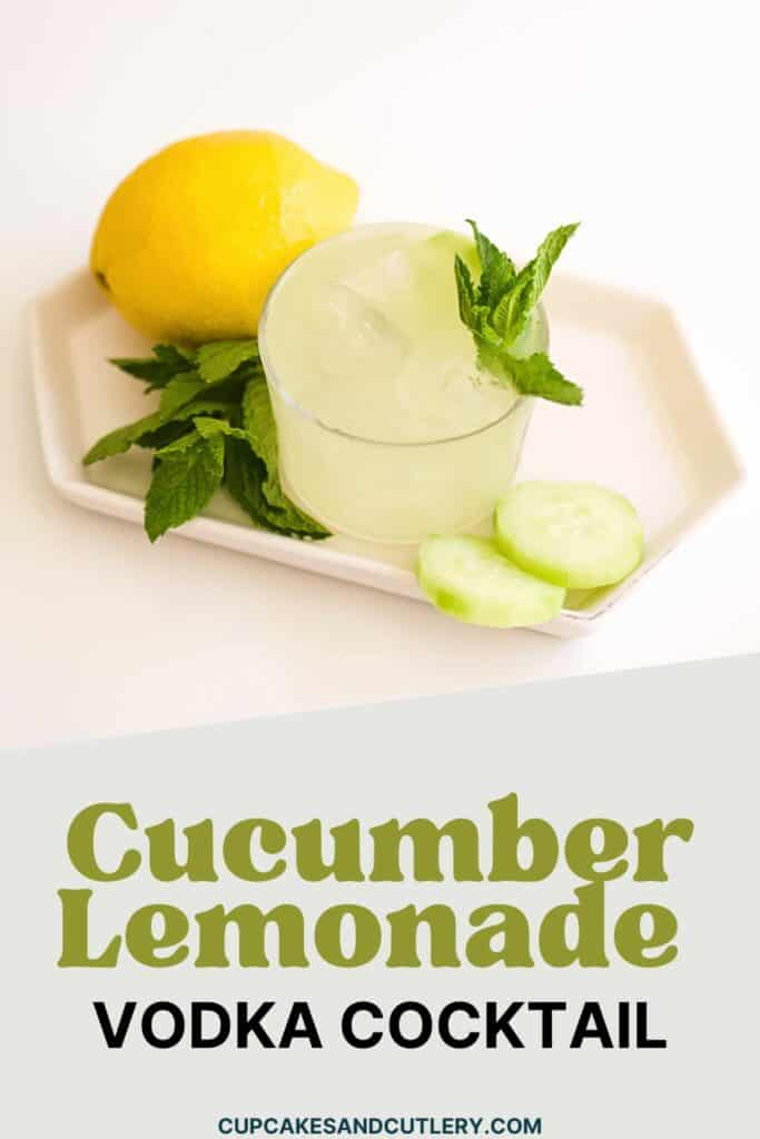 Text - Cucumber Lemonade Vodka Cocktail with a cocktail topped with mint on a small tray with sliced cucumber and a lemon .
