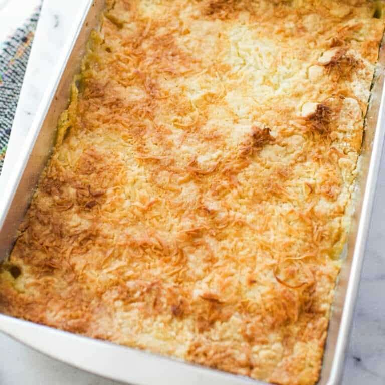 Close up of a mandarin orange dump cake topped with coconut in a baking dish.