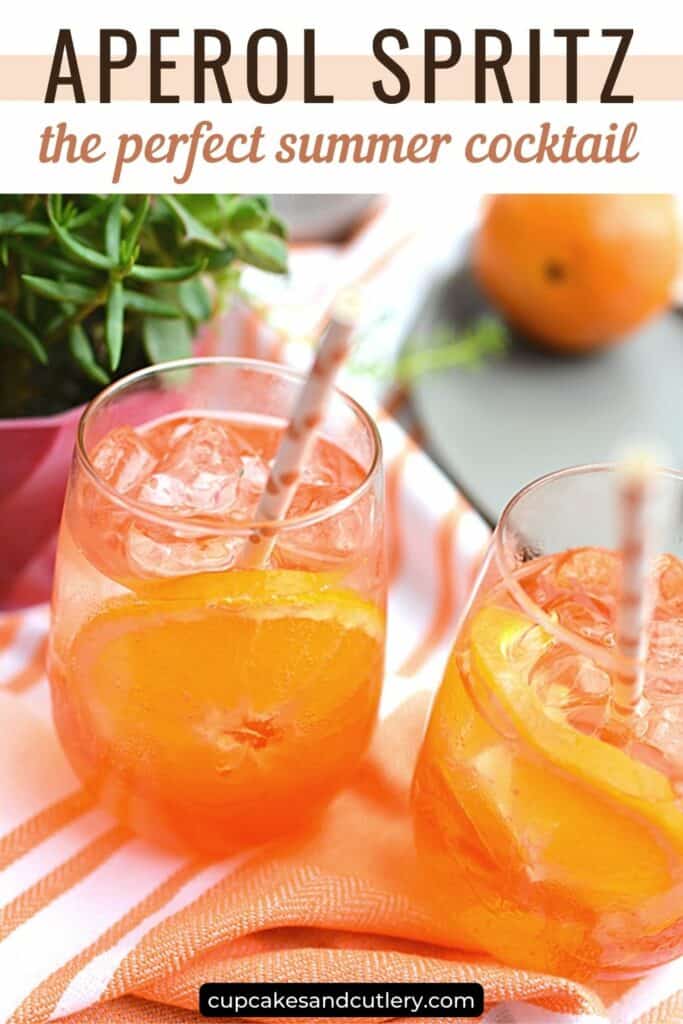 Text - Aperol Spritz, the perfect summer cocktail, with 2 stemless wine glasses holding an Aperol Spritz cocktail.