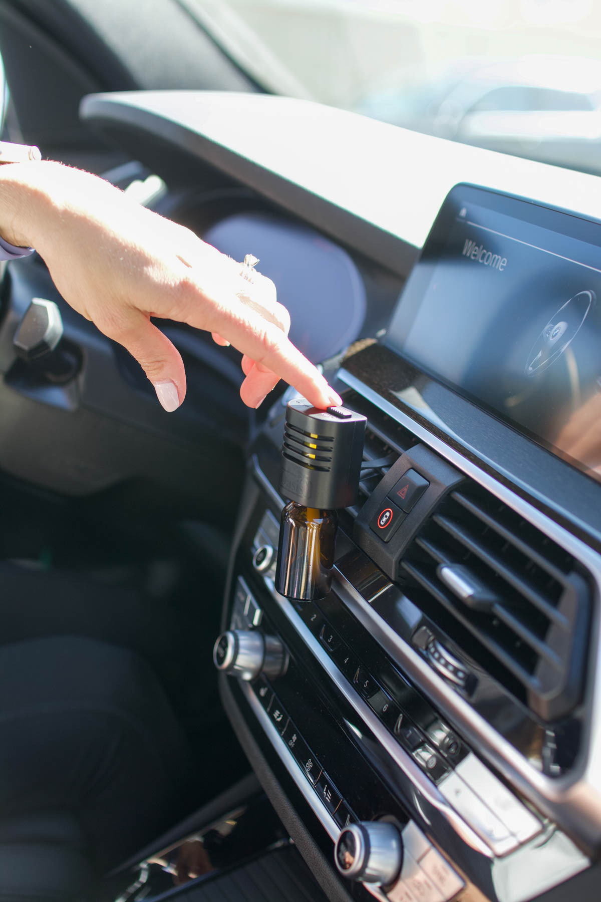 Woman using a fragrance diffuser in her car.