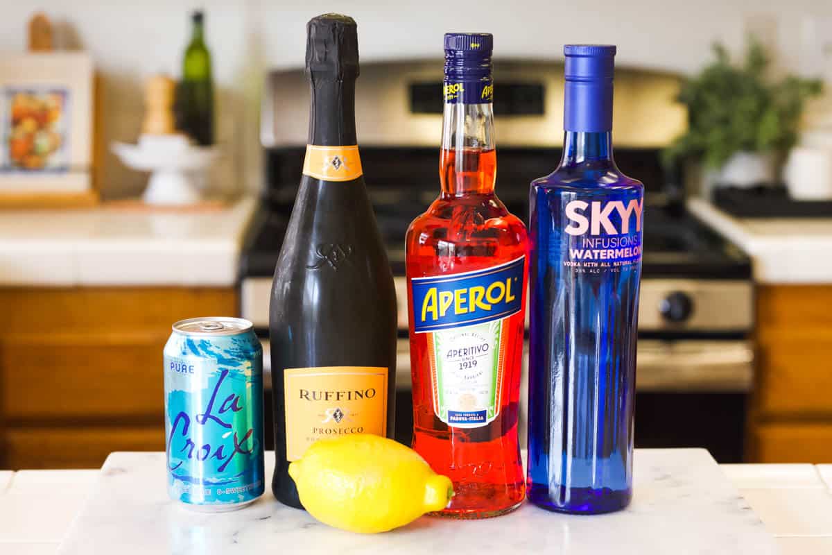 Ingredients on a counter to make a Watermelon Vodka Cocktail with Aperol.