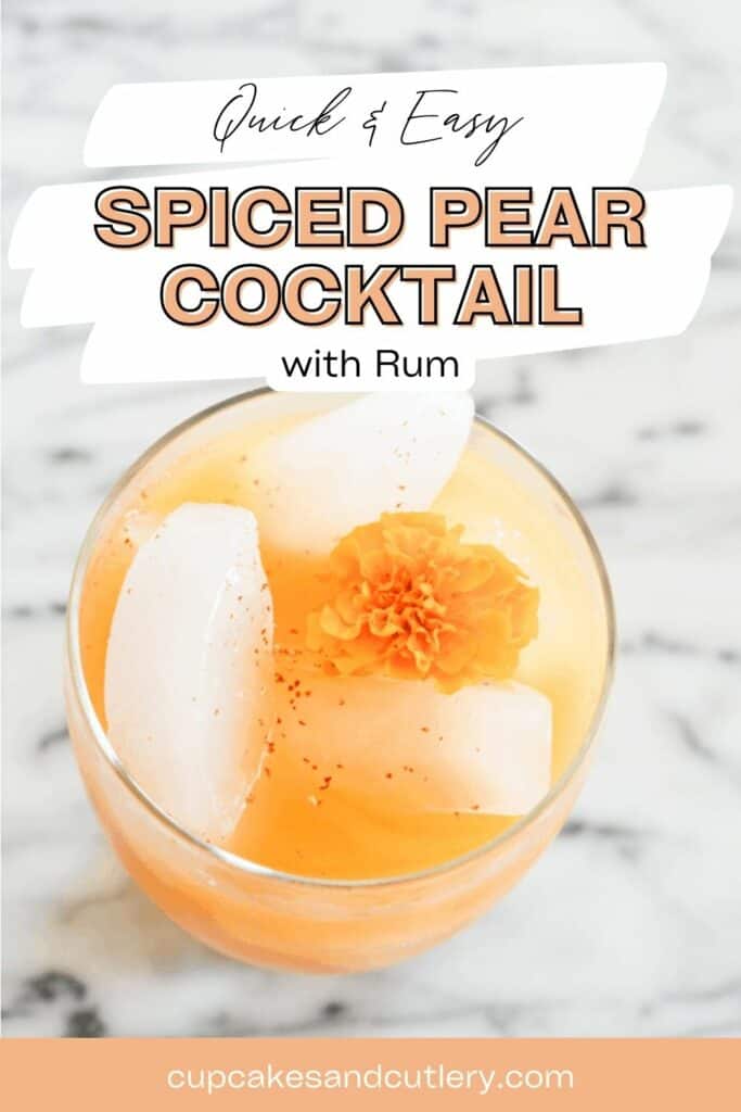 Text: Quick and easy spiced pear cocktail with rum with a cocktail with ice and an edible flower i the glass.