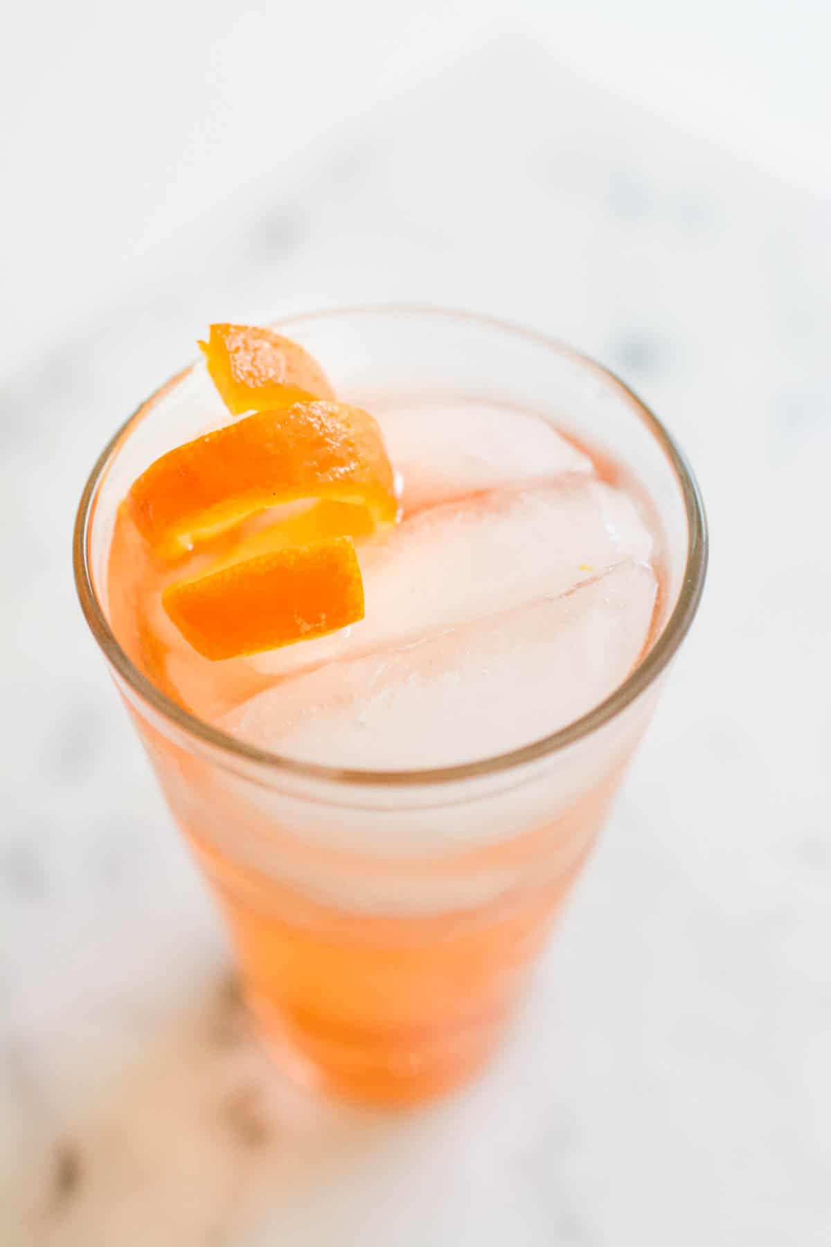 A cocktail with a citrus spiral garnish on top.