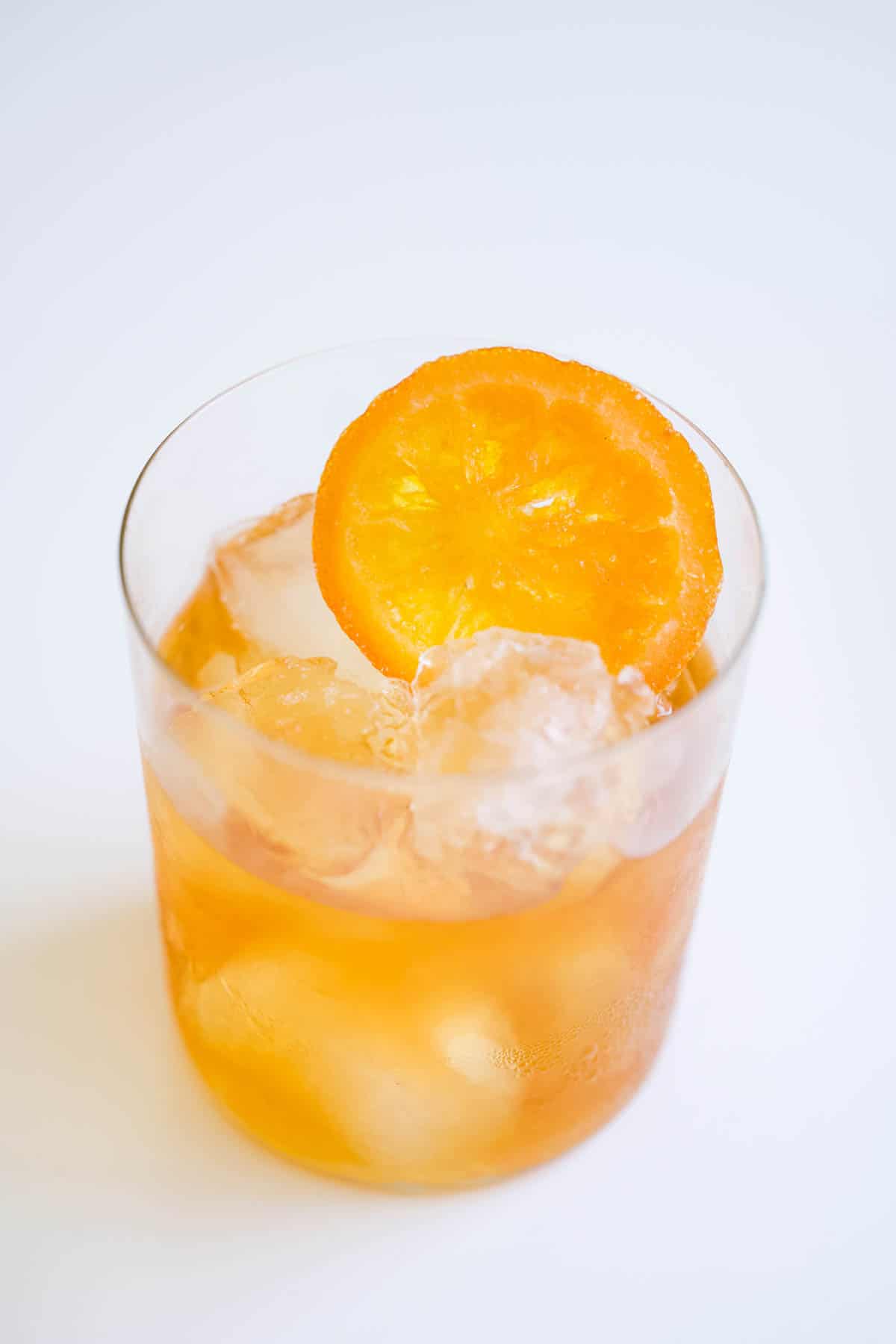 A dried orange wheel in the top of a cocktail glass with ice.