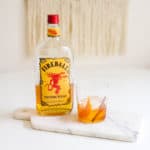 A cocktail glass on a table with Fireball Old Fashioned.