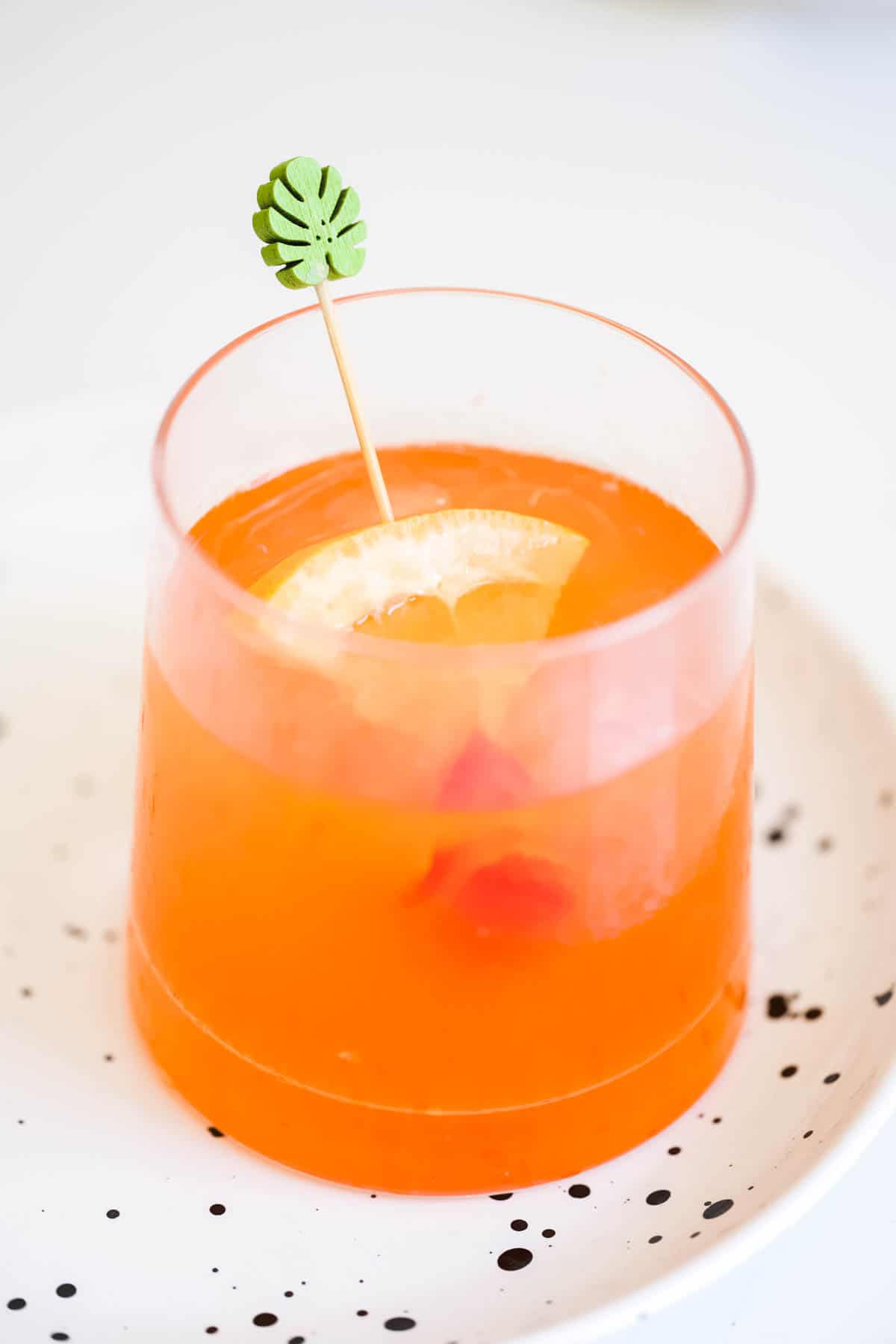 Leaf pick with fruit garnish in a cocktail.