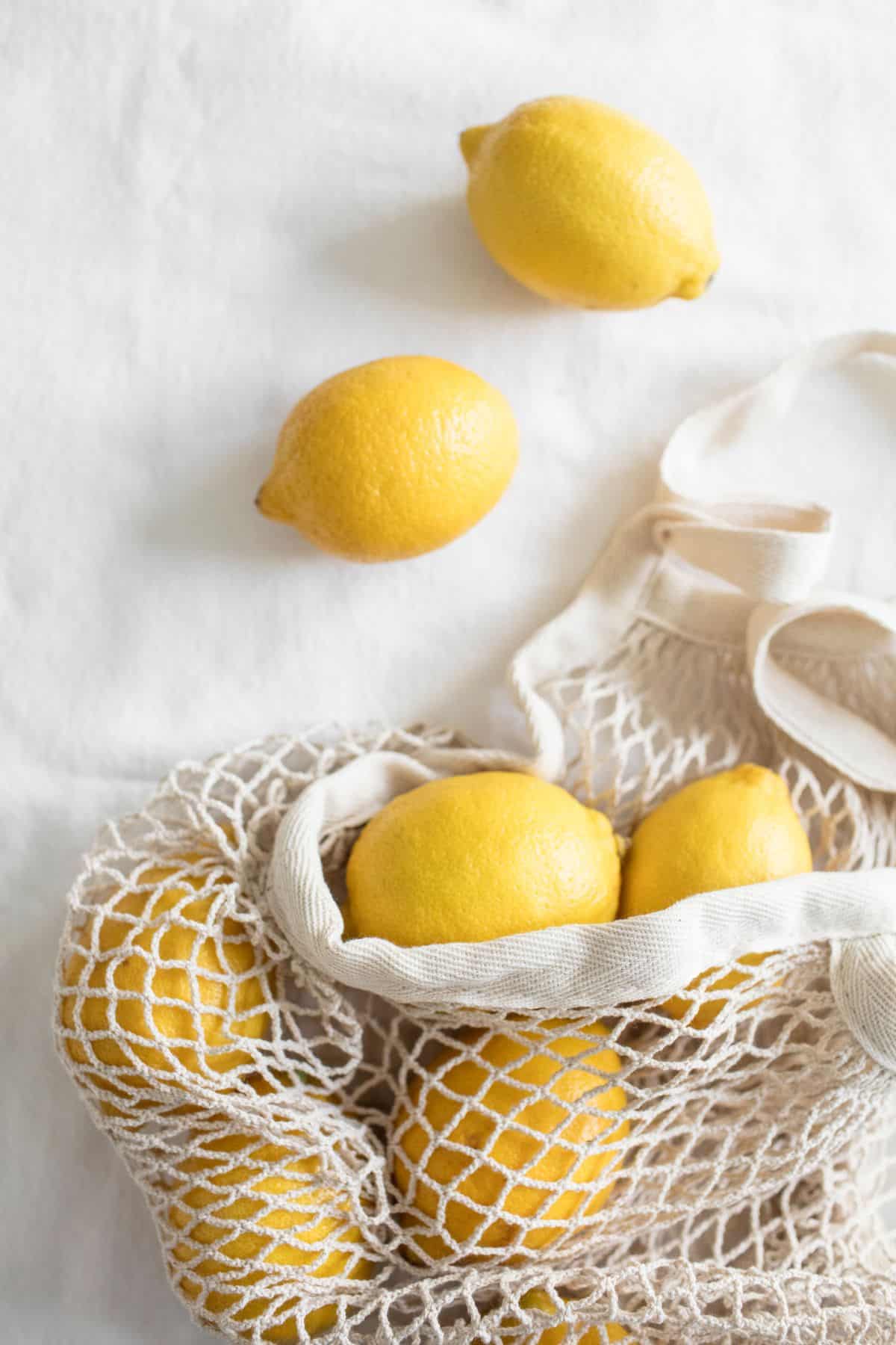 Reusable grocery bag of lemons on a counter. 