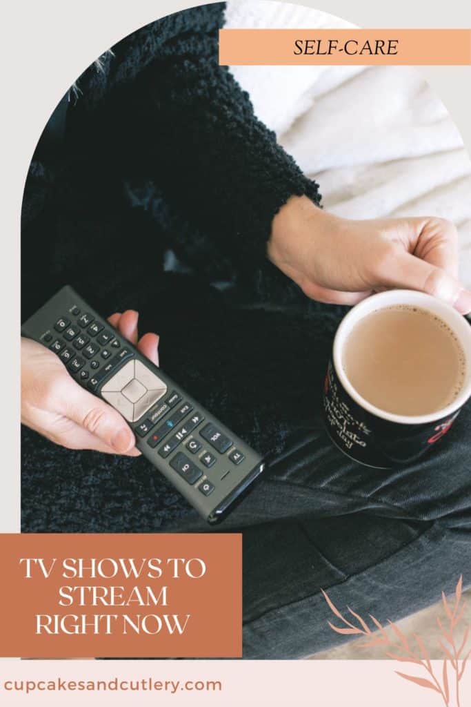 A close up of a woman on the couch holding a cup of coffee and a remote control.
