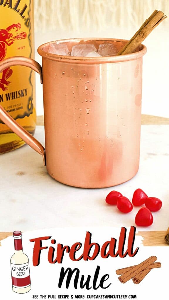 Text: Fireball Mule with a copper mug holding a Mule cocktail made with cinnamon whisky and garnished with a cinnamon stick.