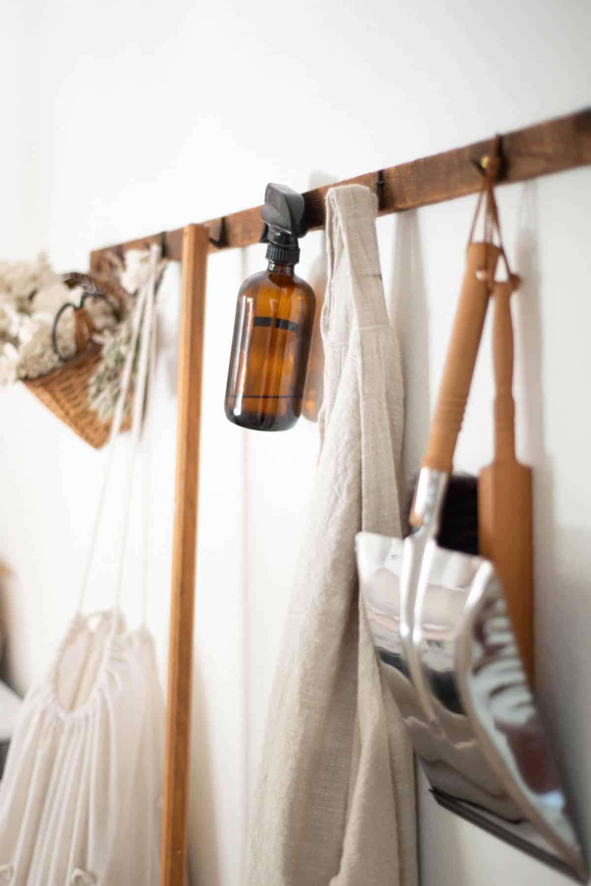 Cleaning supplies hanging from pegs on a wall.