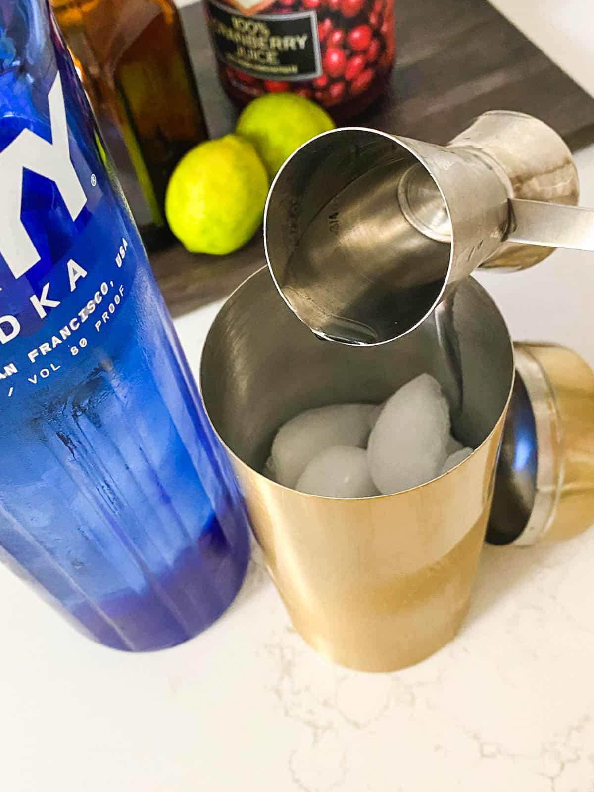 Vodka being poured into a cocktail shaker.