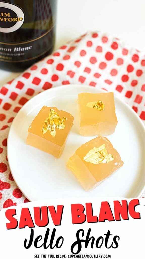 Text: Sauv Blanc Jello Shots with a small white plate holding 3 squares of golden jello with edible gold leaf on top.