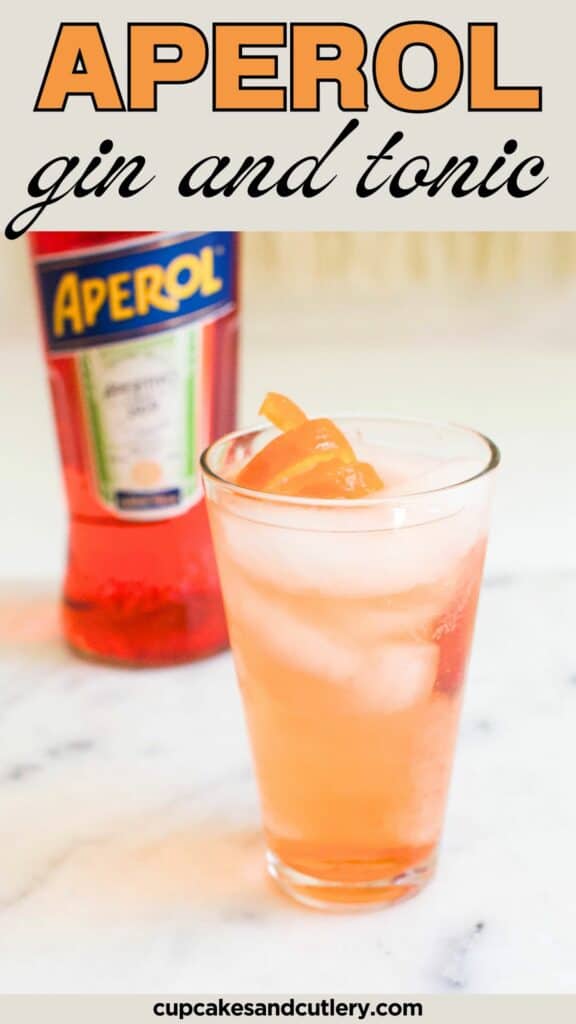 Text: Aperol Gin and Tonic with a cocktail glass on the table holding an orange colored drink next to a bottle of Aperol.