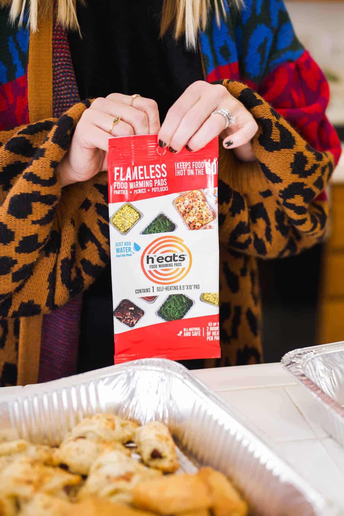 A woman opening a package with a heat pack to keep appetizers warm.