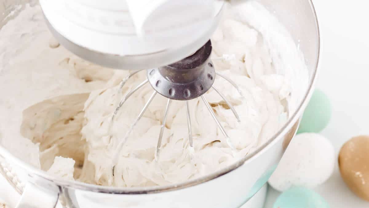 Cake mix cream cheese dessert dip being beaten in the bowl of a stand mixer.