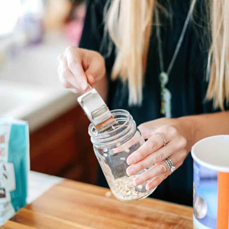 A woman preparing overnight oats in her kitchen.