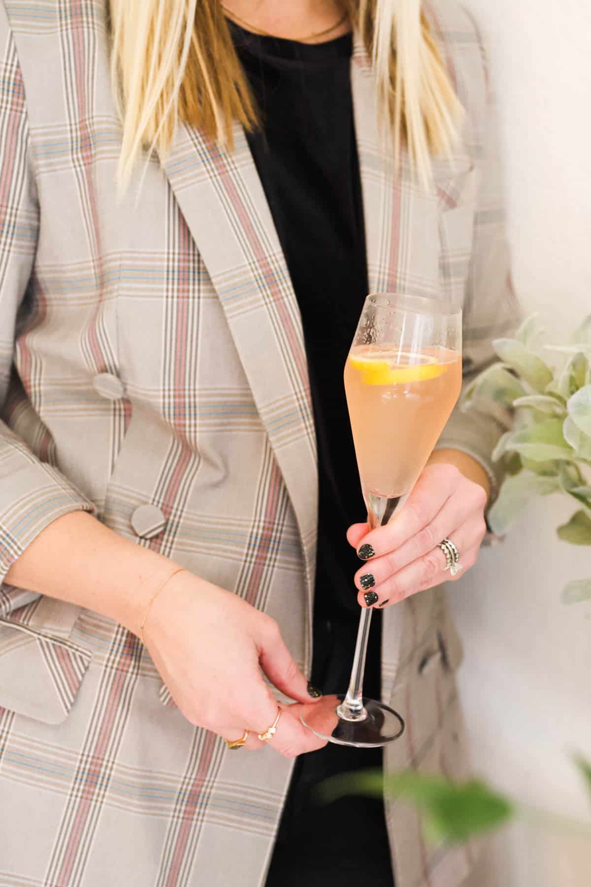 Woman holding a St Germain Champagne Cocktail.