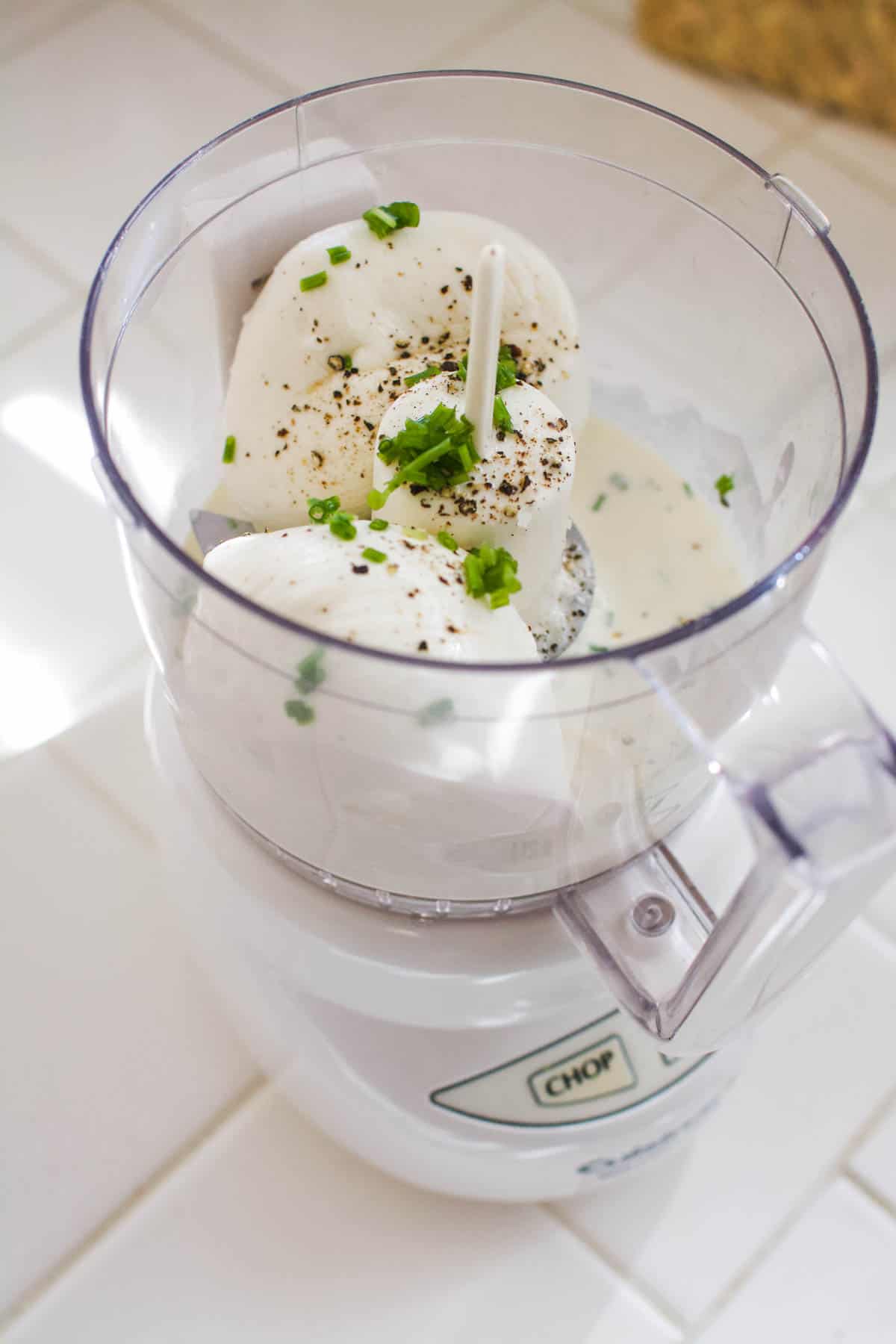 A mini food processor filled with ingredients to make truffle burrata dip.