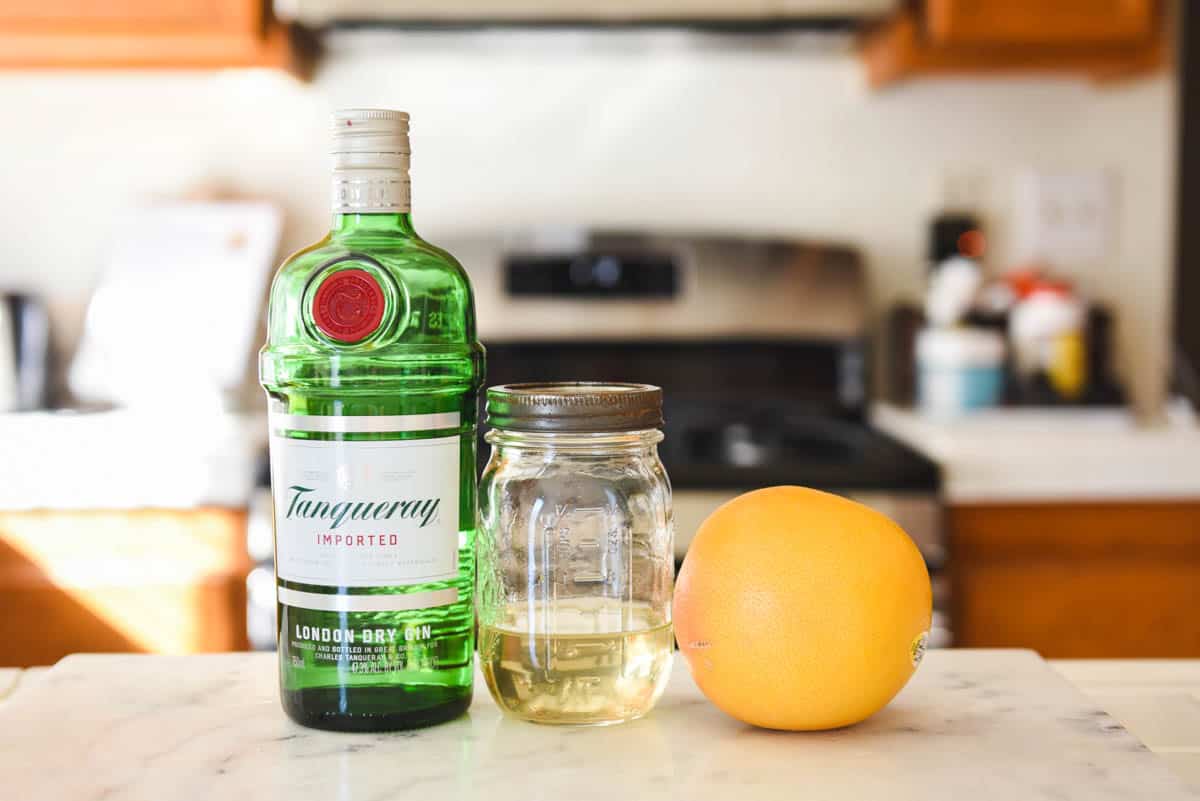 Ingredients for a grapefruit gin cocktail on the kitchen counter.
