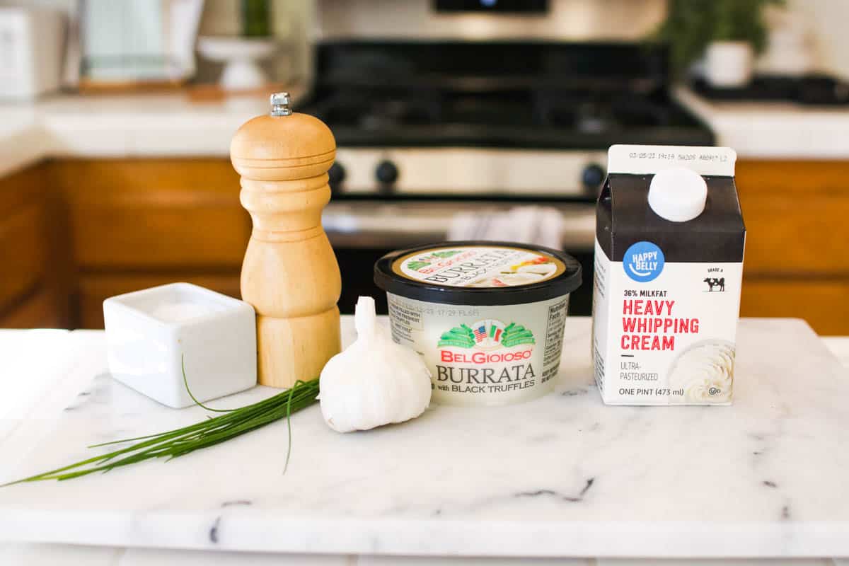 Ingredients to make an easy truffle burrata dip recipe on a marble counter top.