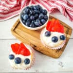 White frosted angel food cake cupcakes topped with blueberries and strawberries for fourth of july.