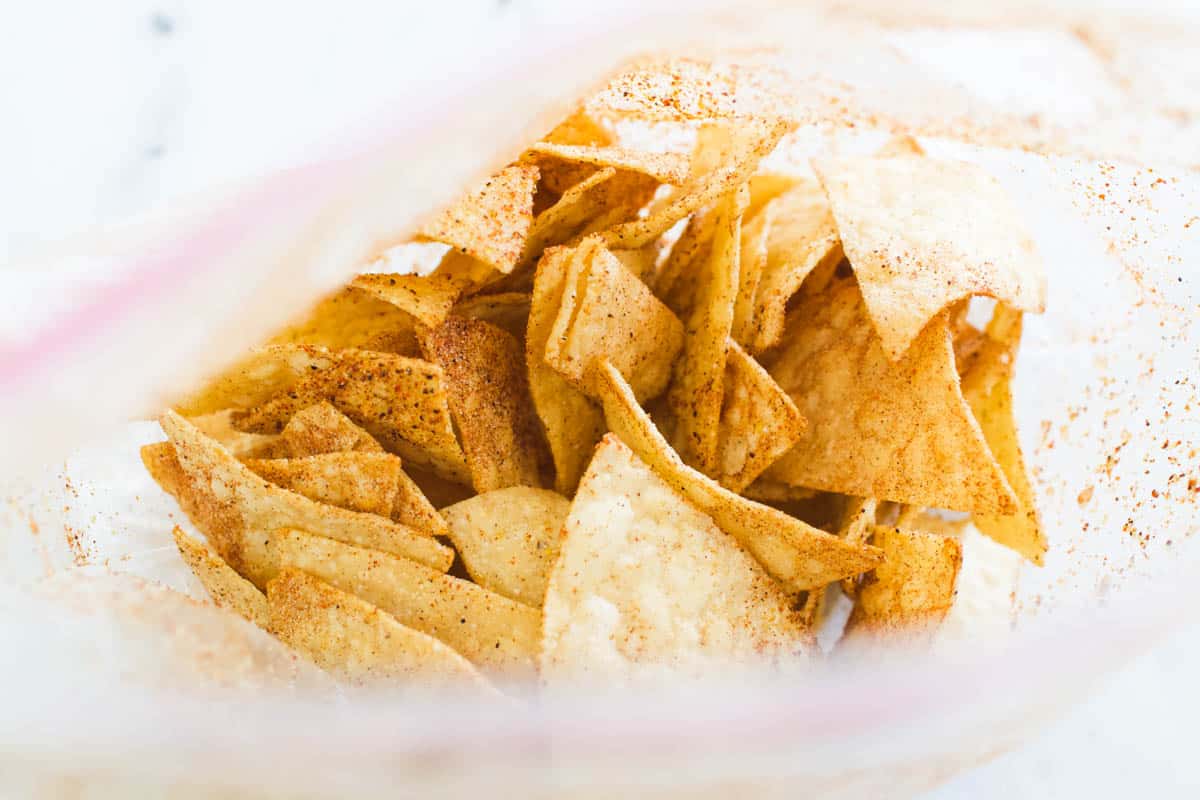 A plastic Ziplock bag filled with tortilla chips to be seasoned.