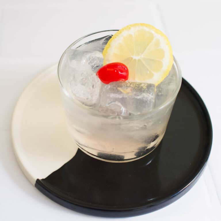 Close up of a vodka sour on a black and white tray.