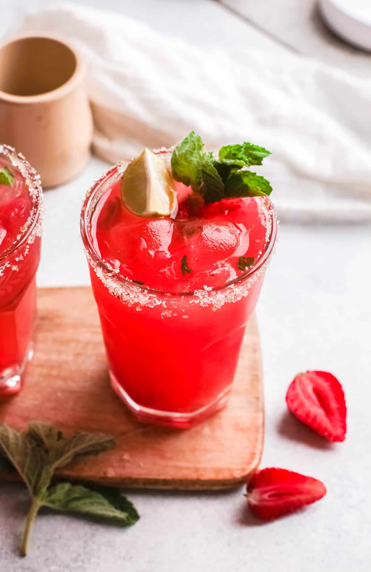 Strawberry and tequila cocktails on a wooden board.