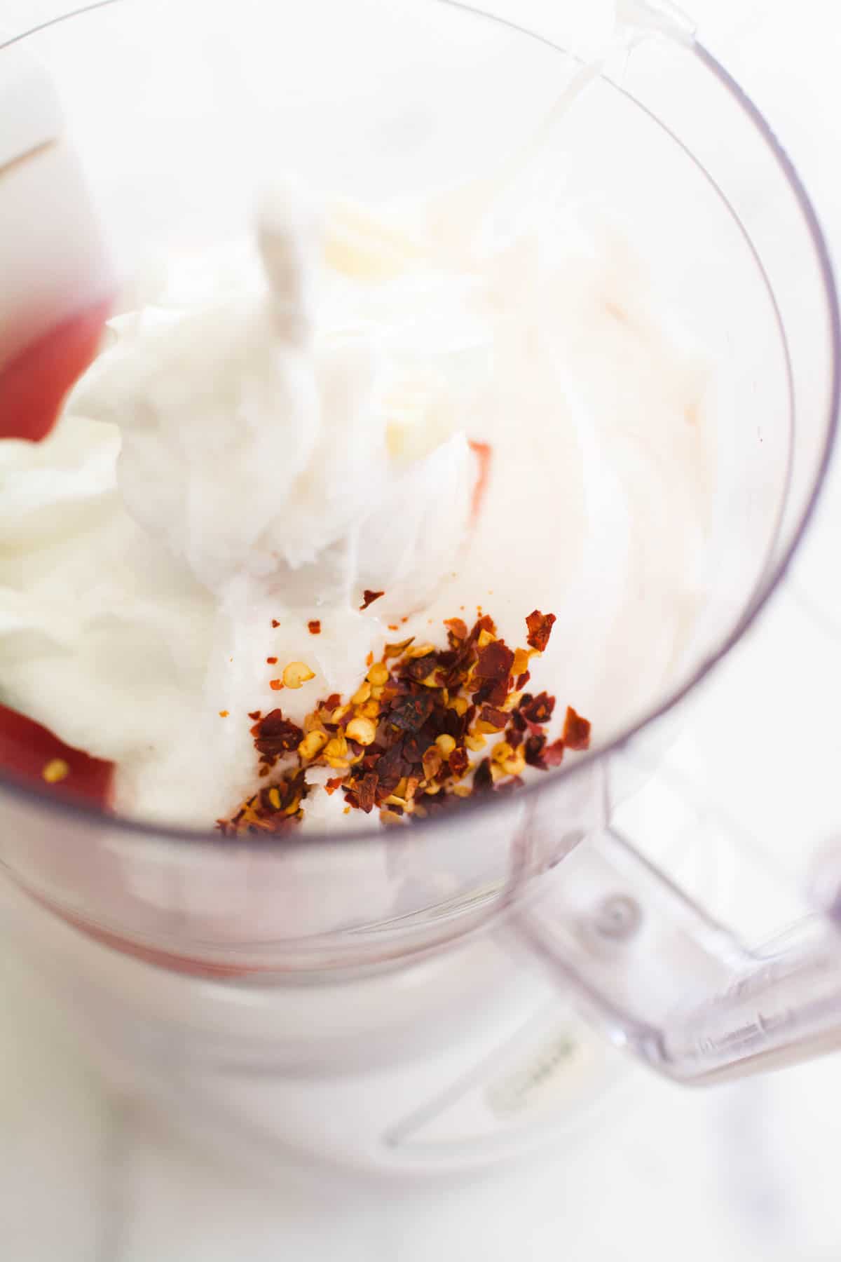 A food processor filled with greek yogurt and spices.