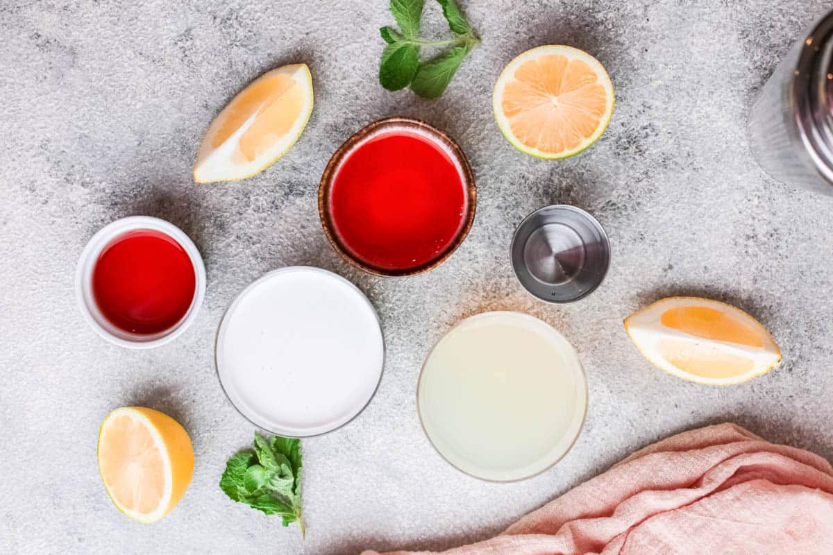 The ingredients to make a Coconut Daiquiri with Aperol in small bowls on a table.