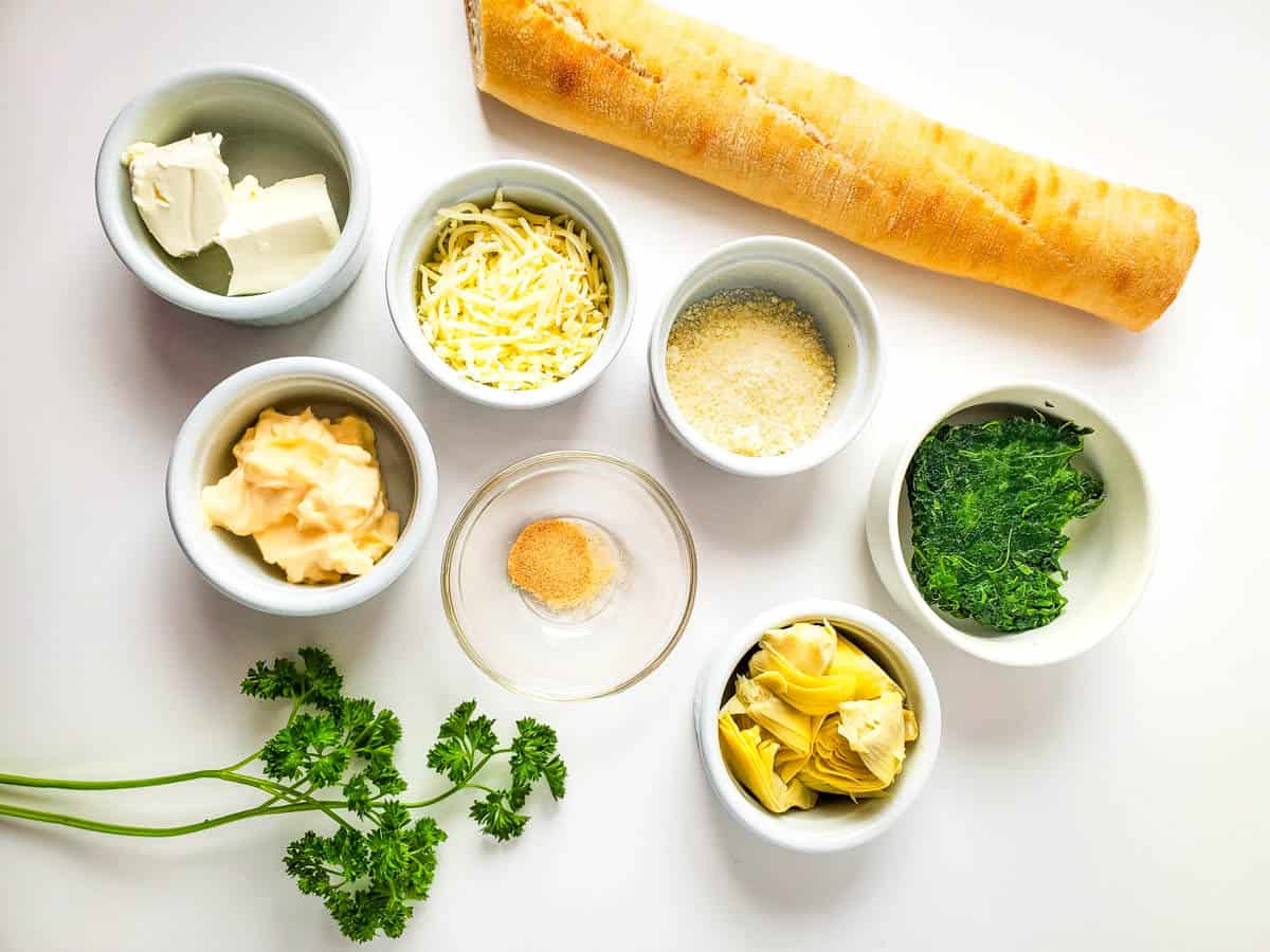 Ingredients to make a spinach artichoke dip crostini.