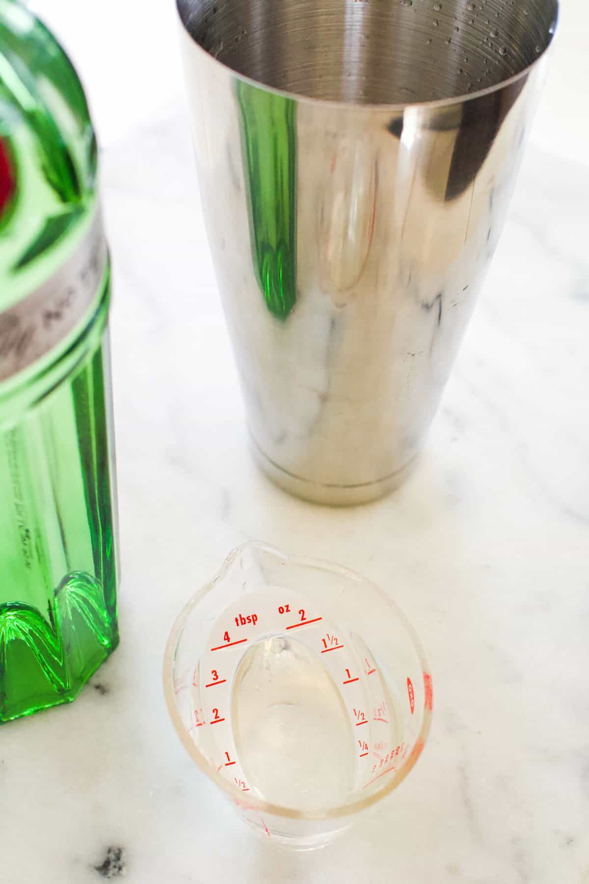 Gin being measured into a cocktail shaker.