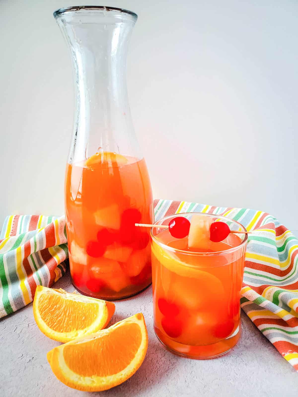 Sangria with rum and passion fruit juice in a pitcher and a short glass.