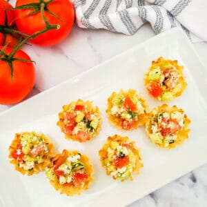 Phyllo cups filled with tomato and cucumber salad with Mediterranean flavors.