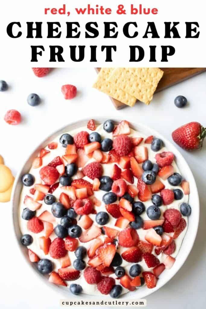 Text - Red, White and Blue Cheesecake Fruit Dip with Fresh blueberries, raspberries and strawberries topping a cheesecake dip with graham crackers next to the bowl.