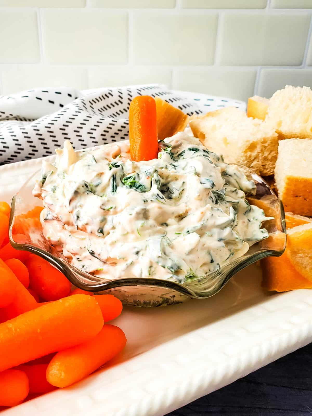 A glass bowl filled with an easy spinach dip.