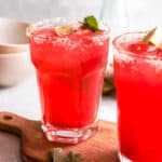 Close up of a strawberry cocktail garnished with lime and mint.