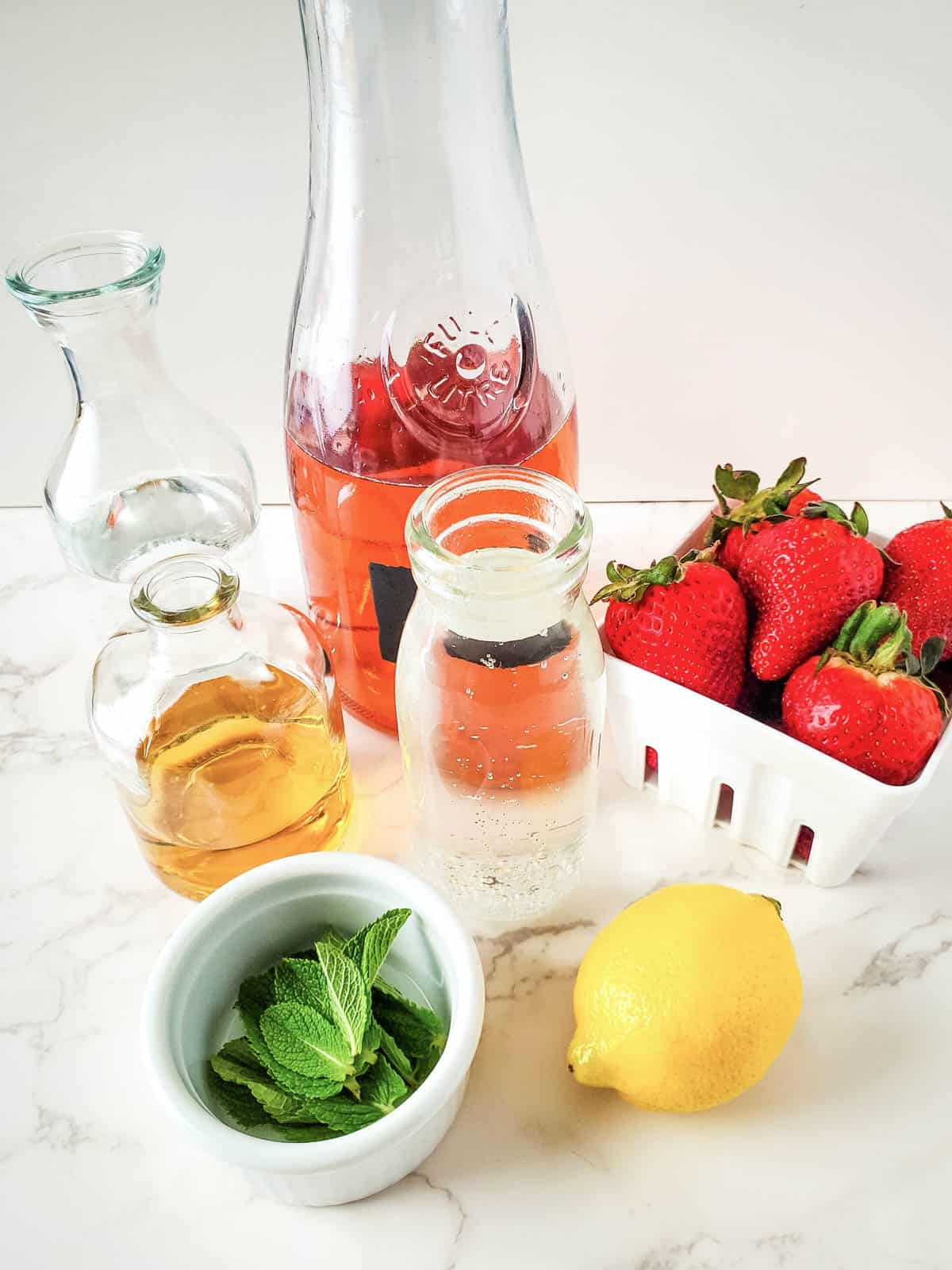 Strawberry wine sangria ingredients on a white countertop.
