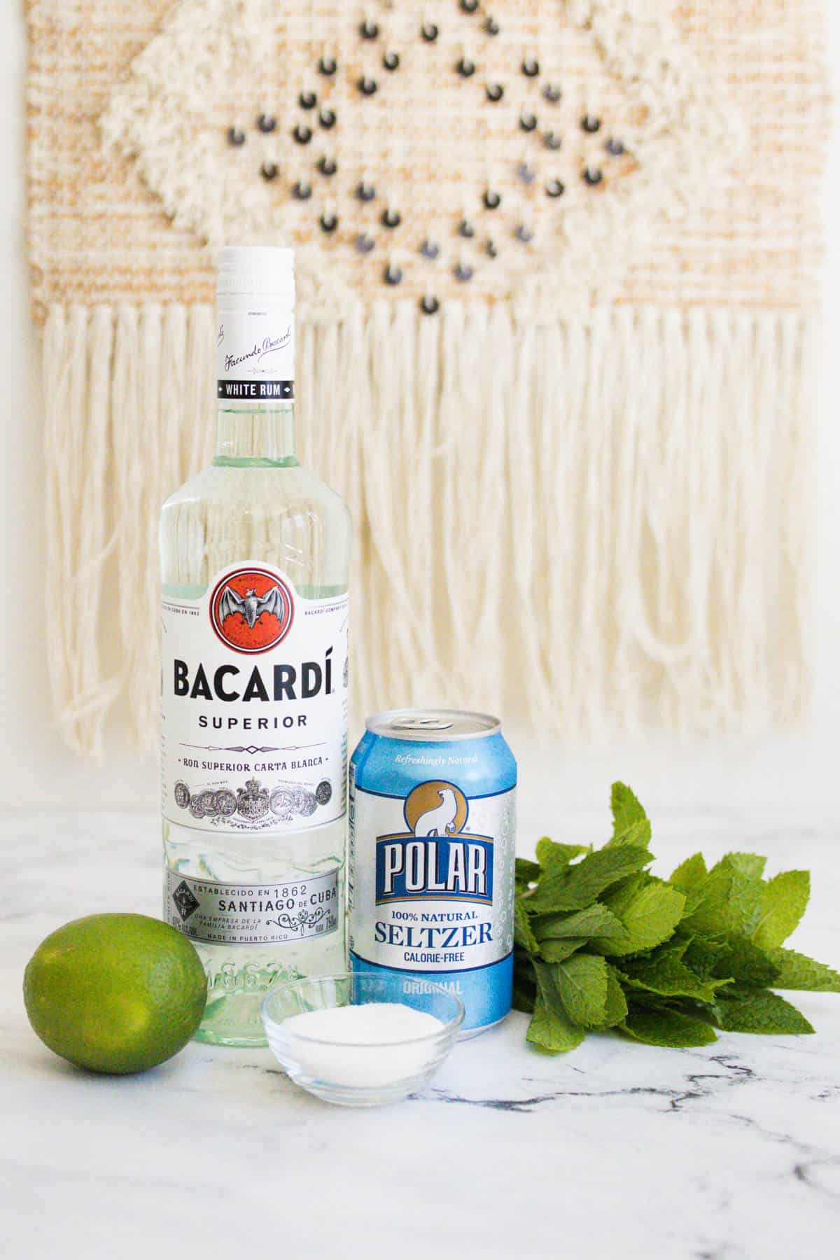 Classic mojito ingredients on a marble countertop.